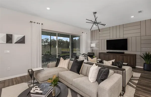 a living room with furniture a flat screen tv and a large window