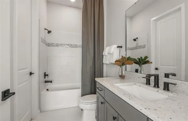 a bathroom with a granite countertop sink a toilet and shower