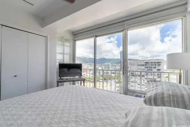 a bedroom with a bed and a large window