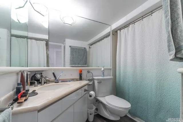 a bathroom with a granite countertop sink a toilet and a mirror