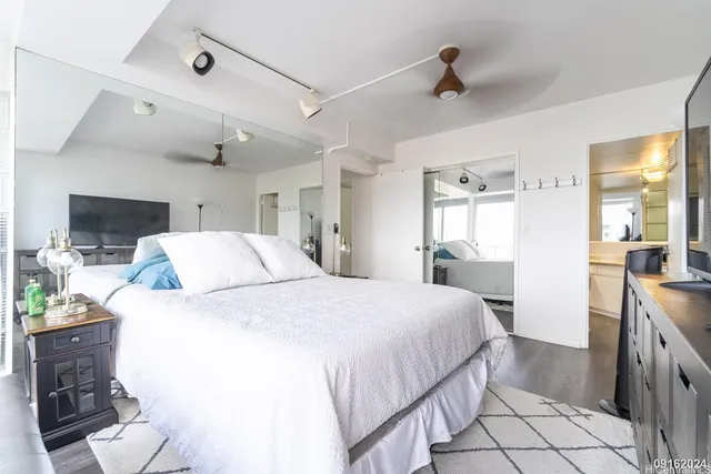 a spacious bedroom with a bed and a view of kitchen