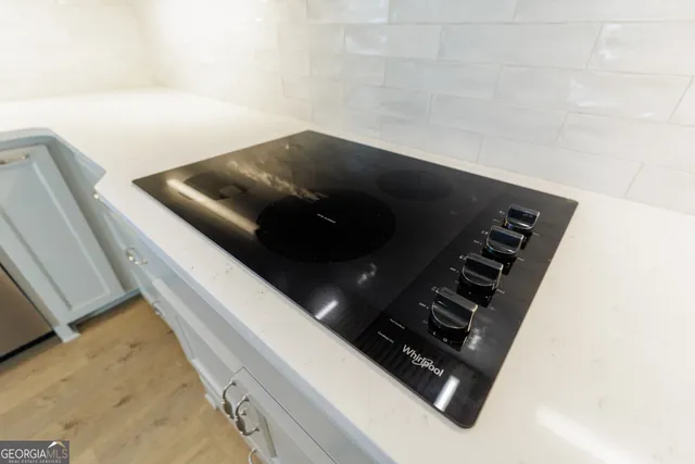 a view of a hallway with wooden floor and chandelier