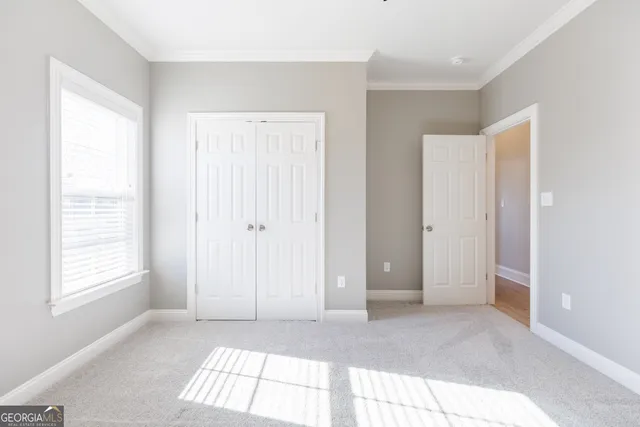 an empty room with chandelier fan and windows