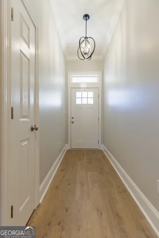 a view of an empty room with wooden floor and a ceiling fan