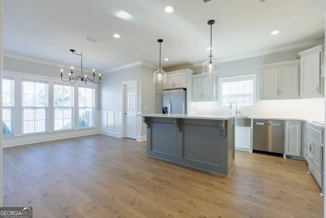 a large kitchen with granite countertop a large counter top stainless steel appliances and cabinets