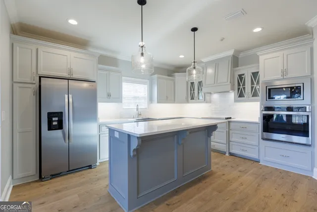 a kitchen with granite countertop a sink stainless steel appliances and cabinets