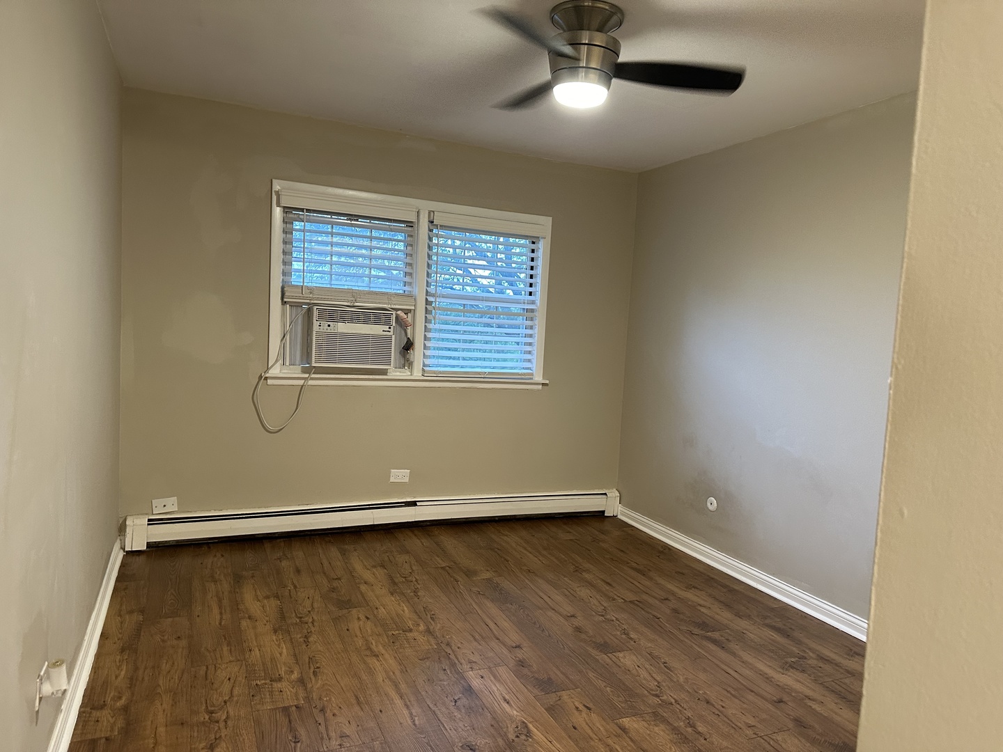 2327 Ogden Avenue, Unit 10 Downers Grove, IL 60515 - Photo 14 of 17 an empty room with wooden floor fan and windows