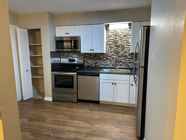 a kitchen with stainless steel appliances granite countertop a stove and a refrigerator