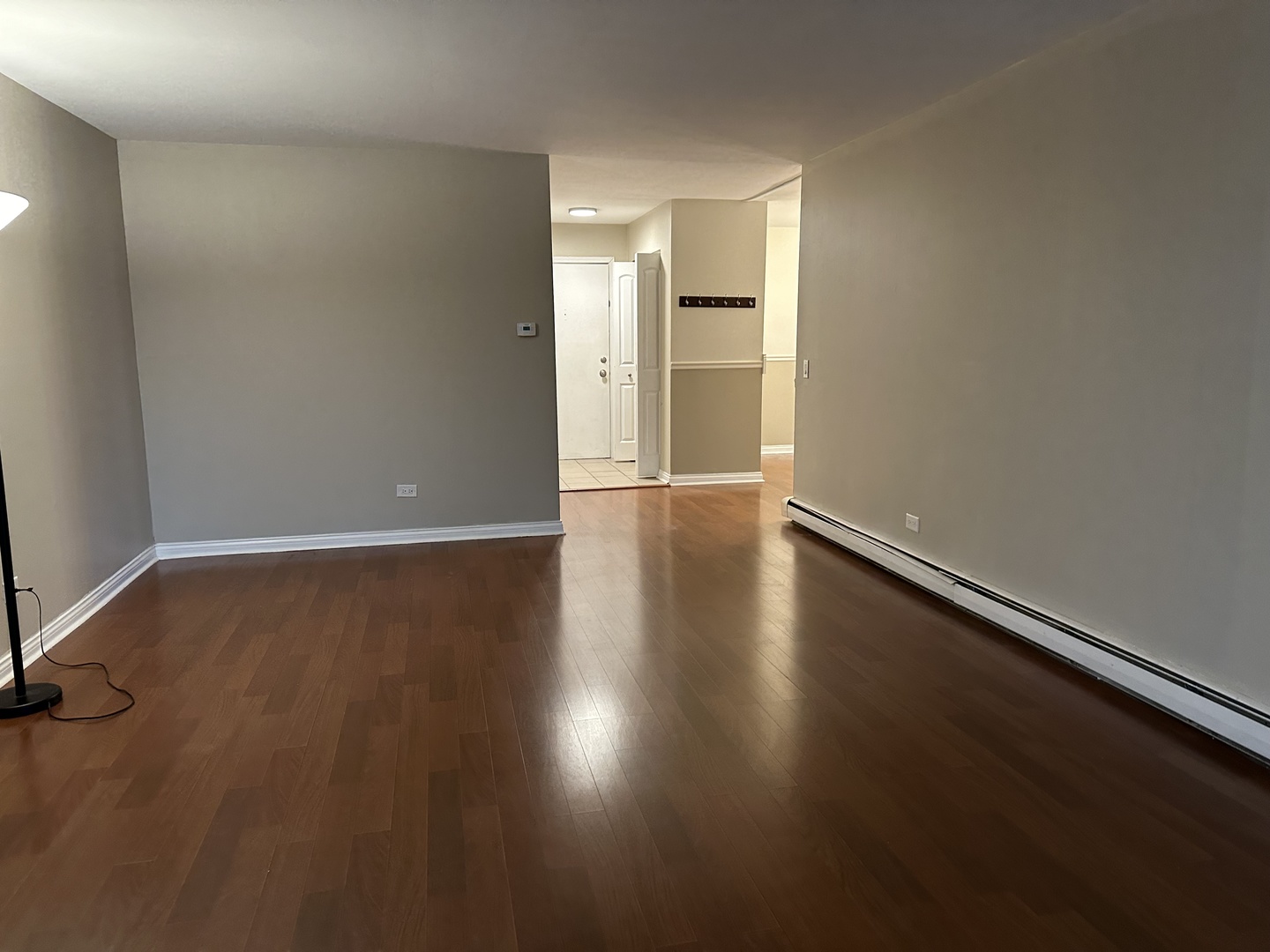 2327 Ogden Avenue, Unit 10 Downers Grove, IL 60515 - Photo 10 of 17 an empty room with wooden floor and windows with curtains