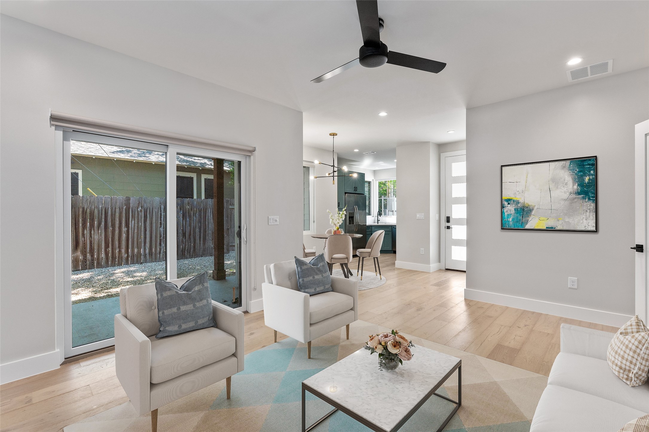 5200 Grover Avenue Austin, TX 78756 - Photo 11 of 32 Virtually Staged. Open-concept living space featuring hardwood finish flooring, recessed lighting, and a modern ceiling fan. View to the backyard and covered deck .