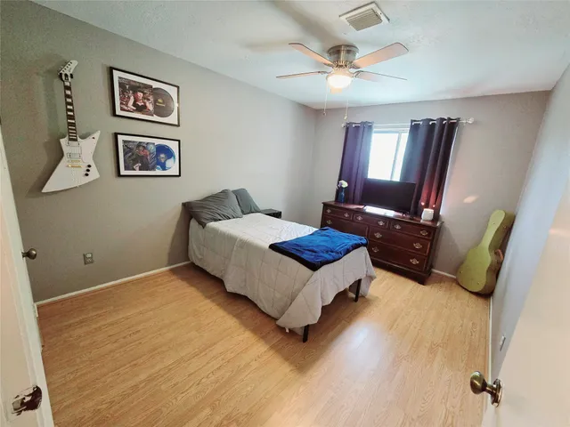 a spacious bedroom with a bed and a chandelier