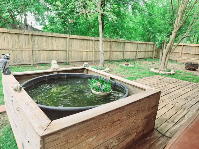 a view of a backyard with a tub and wooden fence