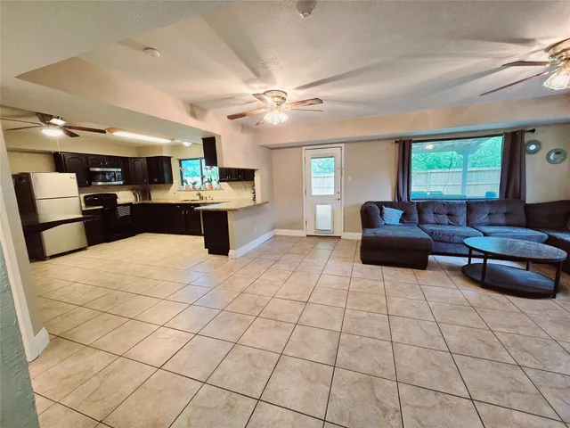 a large room with furniture and a open kitchen view