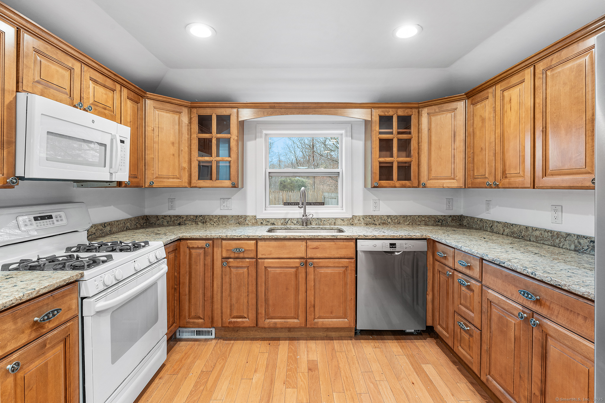 20 Georgetown Road Weston, CT 06883 - Photo 4 of 30 a kitchen with stainless steel appliances granite countertop wooden cabinets a sink and dishwasher a stove with wooden floor