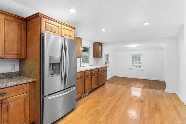 a kitchen with granite countertop stainless steel appliances a refrigerator a stove top oven and sink