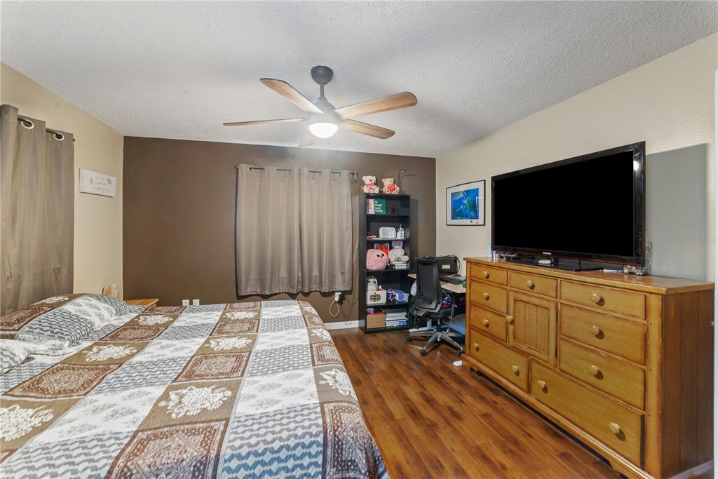 8715 Huntsman Lane Port Richey, FL 34668 - Photo 25 of 54 a bedroom with furniture and flat screen tv