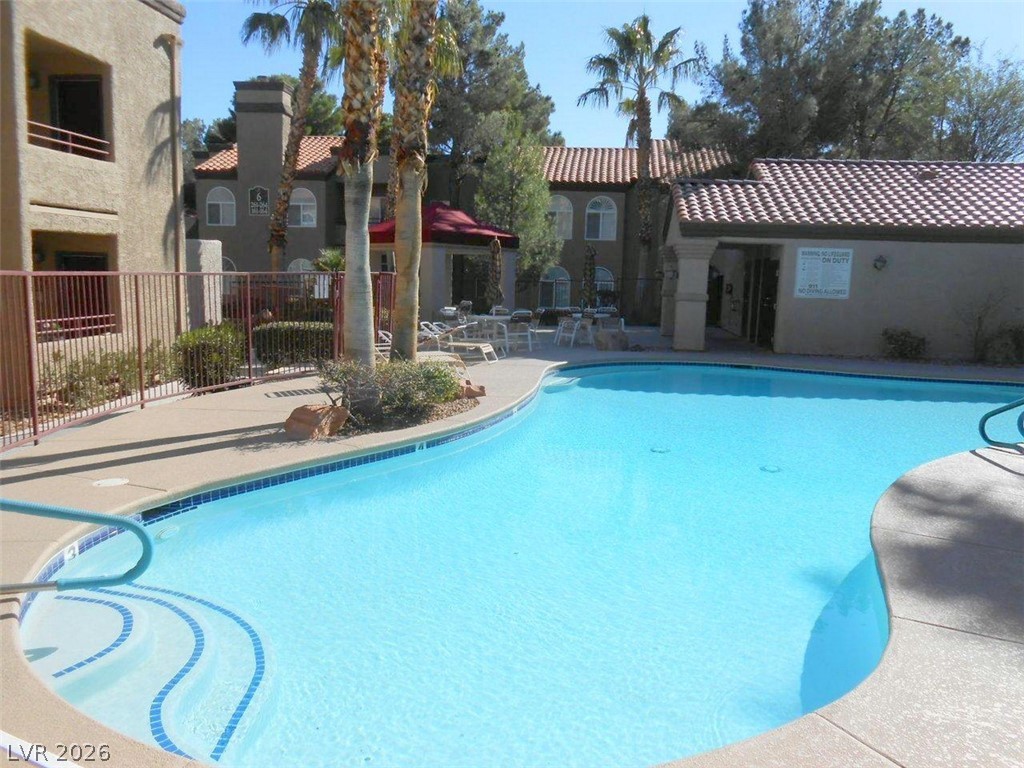 9325 West Desert Inn Road, Unit 132 Las Vegas, NV 89117 - Photo 23 of 36 Relax poolside in this inviting community pool area, surrounded by well-maintained buildings and lush palms.