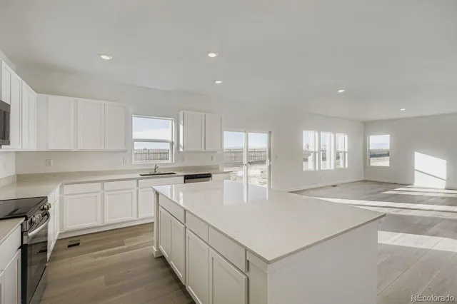 a kitchen with a stove a sink a refrigerator and cabinets