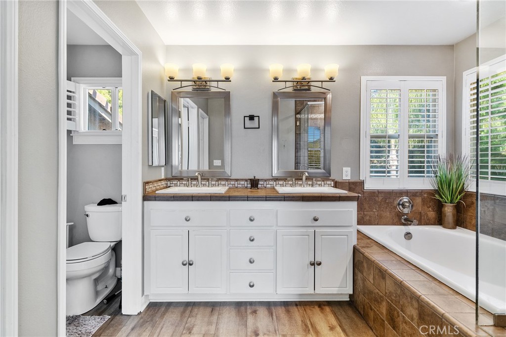 36232 Village Road Yucaipa, CA 92399 - Photo 28 of 34 a spacious bathroom with a granite countertop double vanity sink a mirror and a bathtub
