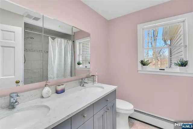 a bathroom with a granite countertop sink toilet and mirror