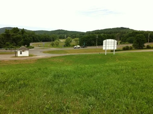 a view of a green field with mountains in the background