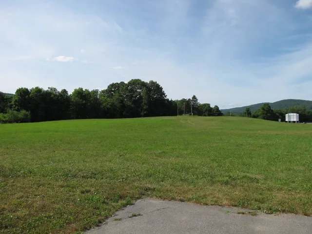 a view of a field with an trees in the background