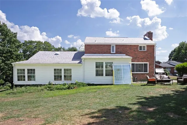 a front view of a house with a yard and trees