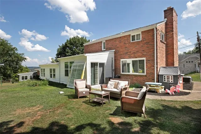 a backyard of a house with fire pit and chairs