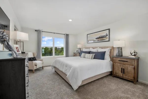 a bedroom with a large bed and a chandelier