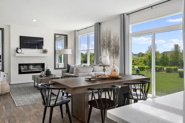 a dining room with a table chairs and a floor to ceiling window