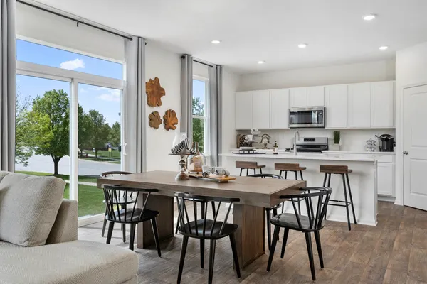 a kitchen with kitchen island a dining table and chairs