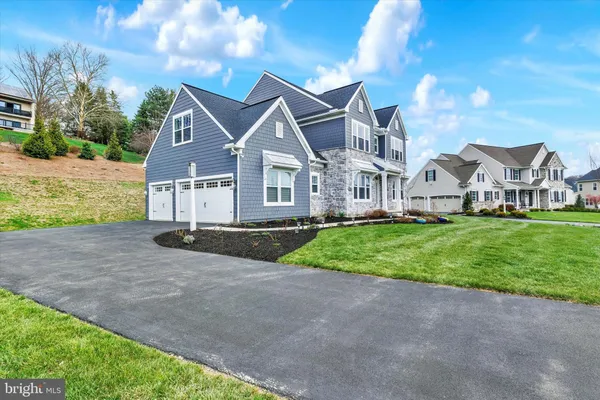 a view of house with a big yard and large trees