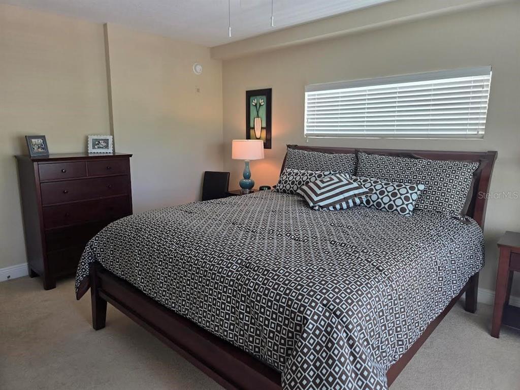 650 Golden Gate Point, Unit 301 Sarasota, FL 34236 - Photo 25 of 31 a bedroom with a bed and wooden floor