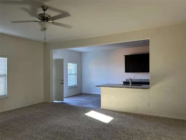 a living room with a flat screen tv and a ceiling fan