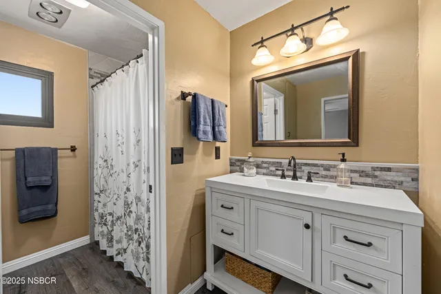 a bathroom with a double vanity sink mirror and shower