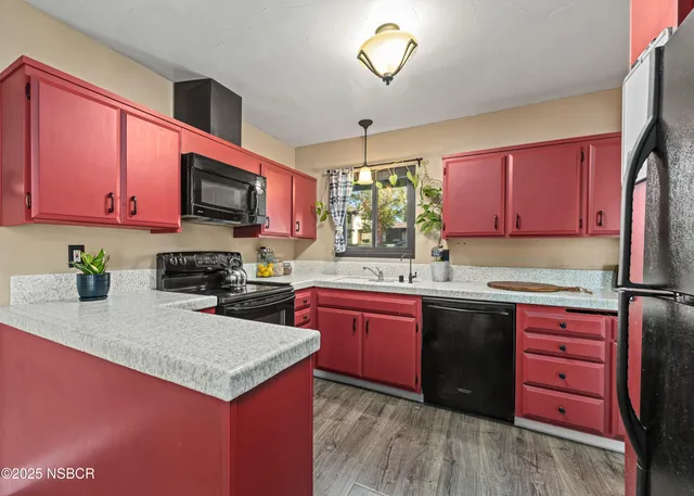 a kitchen with kitchen island granite countertop a sink stove and wooden cabinets