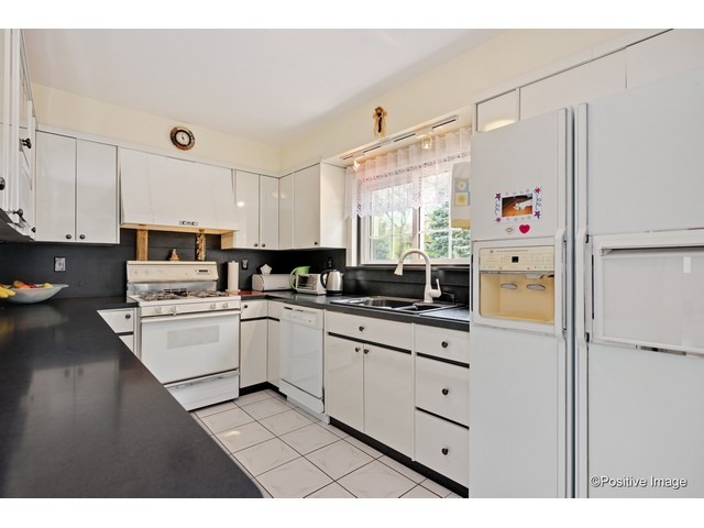 1019 North Delphia Avenue Park Ridge, IL 60068 - Photo 6 of 25 a kitchen with white cabinets and white appliances