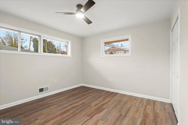 a view of empty room with wooden floor