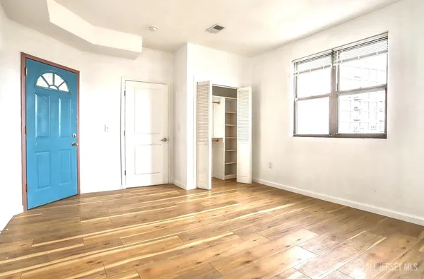 a view of an empty room with window and bathroom