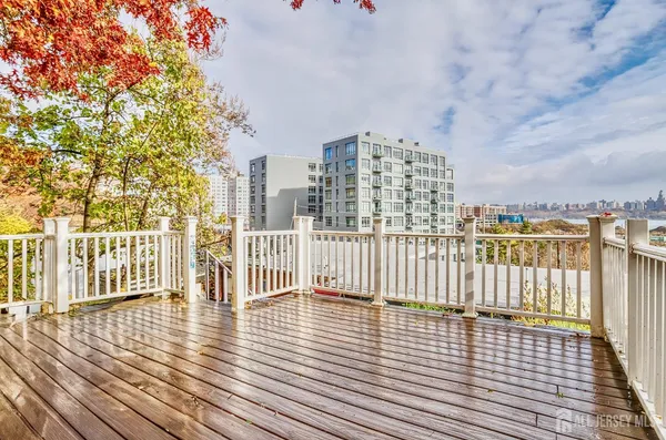 an empty room with wooden floor and fence and city view