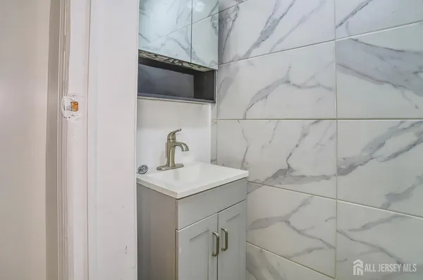 a bathroom with a sink vanity and a shower