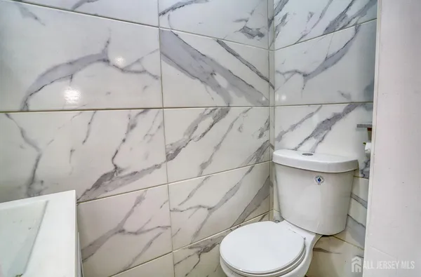 a white toilet sitting next to a white wall