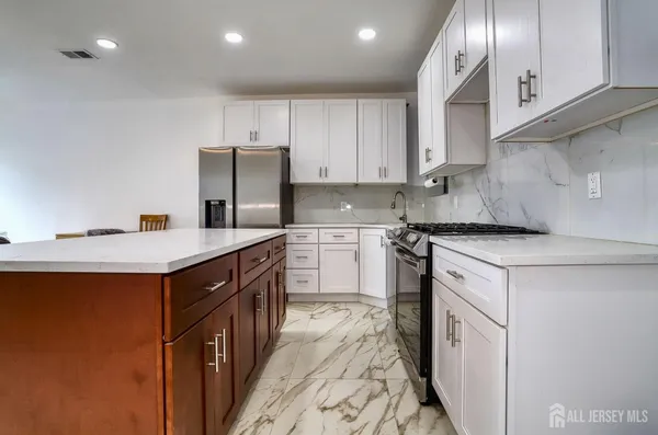 a kitchen with stainless steel appliances granite countertop a sink stove and refrigerator
