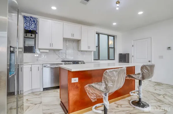 a kitchen with stainless steel appliances granite countertop a sink and cabinets