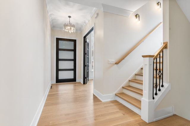 a view of a hallway with wooden floor and entryway
