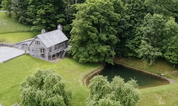 an aerial view of a house with a garden and lake view