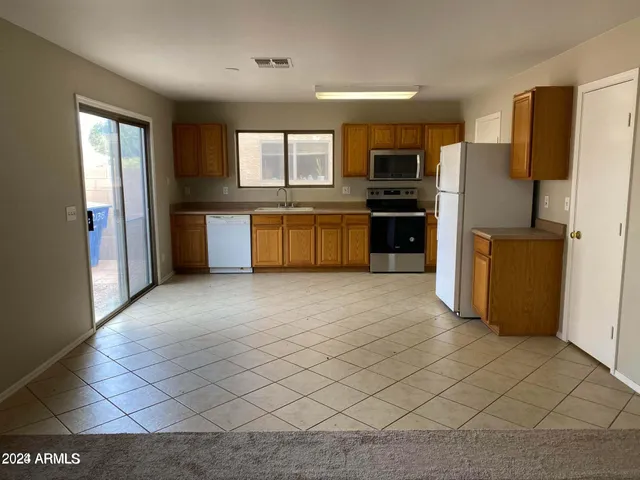 a kitchen with stainless steel appliances a refrigerator and a stove top oven