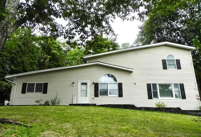 a white house that has a tree in front of the house