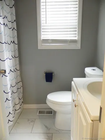 a white toilet sitting next to a bathroom sink