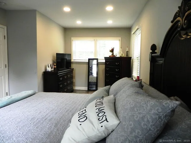 a bedroom with a bed and a flat screen television